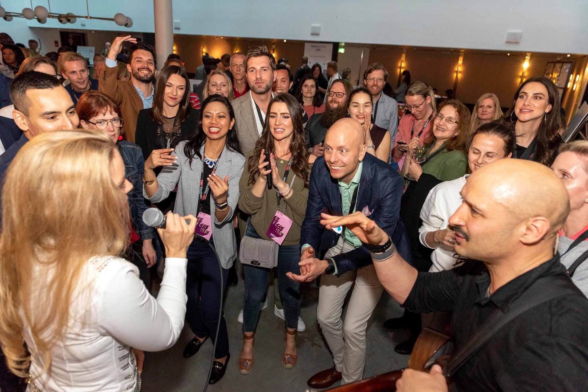 Anna Jois with a microphone among laughing conference guests