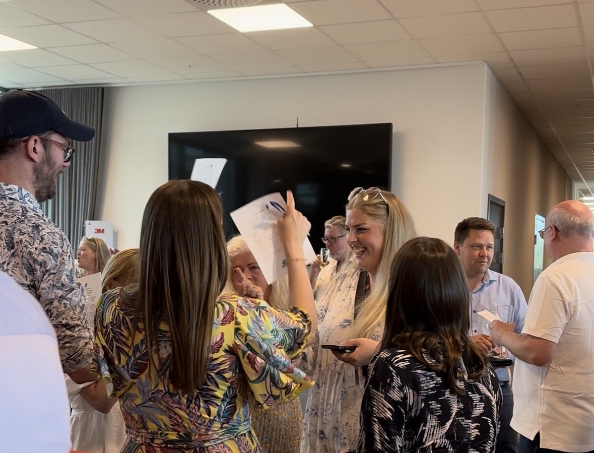 Guests mingle with their bingo cards, laughing